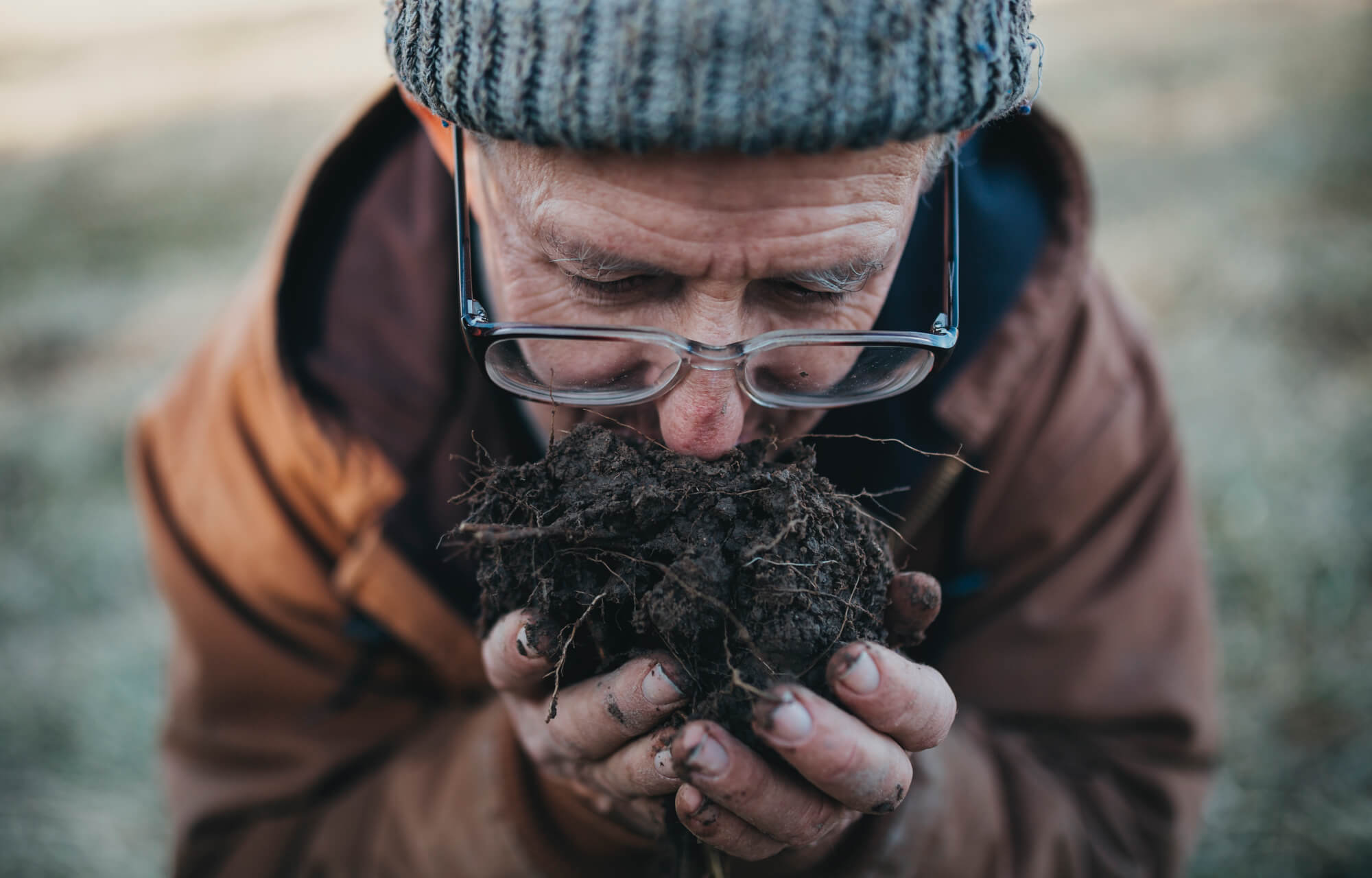 greg judy smelling the soil - regenerative agriculture rancher