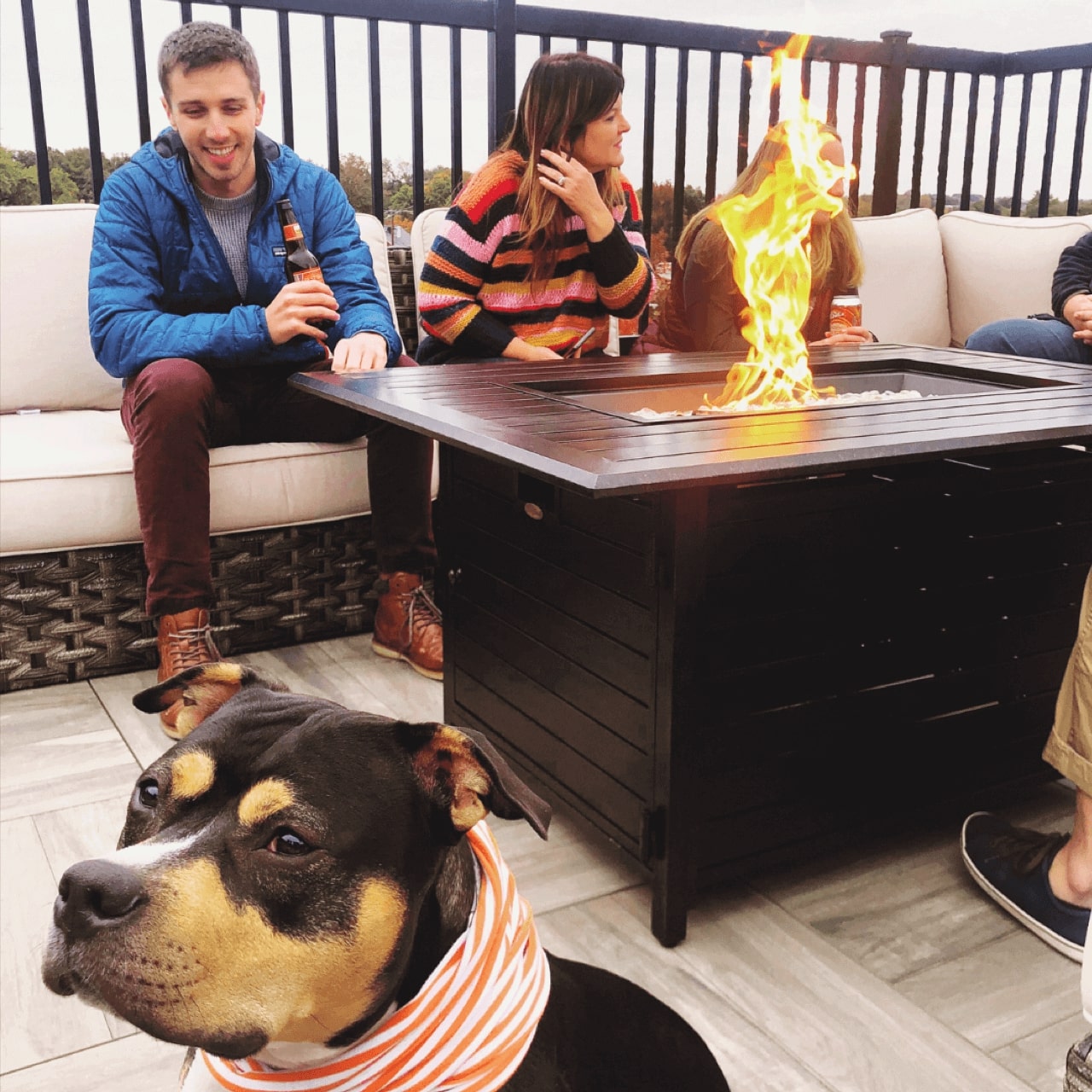 coco the dog, joe, and tracy sitting around a firepit